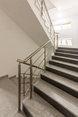 Katlar arasında modern merdiven. Modern binada metal raylı merdivenler