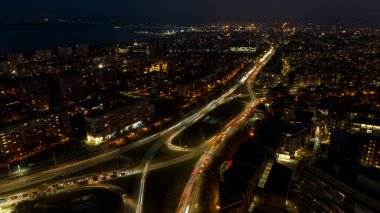 Geceleri şehrin havadan görünüşü. Şehrin sokak trafiği. Şehir Manzarası.