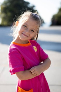 Tatlı küçük kız poz veriyor ve gülümsüyor.