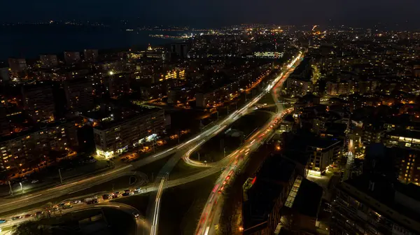 Geceleri şehrin havadan görünüşü. Şehrin sokak trafiği. Şehir Manzarası.
