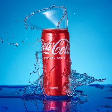 Varna, BULGARIA - 23 Nisan 2024: Klasik Coca Cola tadı, mavi arka planda lekeleri olan kırmızı kutu