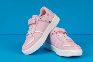 Mavi arka planda pembe çocuk ayakkabıları. Kızlar için çocuk ayakkabıları.