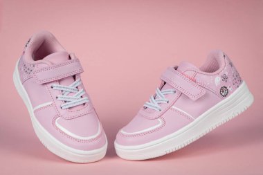 Pembe arka planda pembe çocuk ayakkabıları. Kızlar için çocuk ayakkabıları.