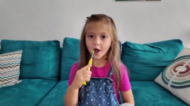 Dişlerini fırçalayan genç bir kız. Diş hijyeni. Diş fırçası olan çocuk.