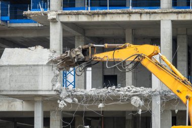 Evin yıkımında hidrolik çökerticili kazı makinesi var. Ev özel makineler tarafından yıkılıyor.. 