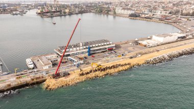 Aerial view of breakwater construction. Crane puts tetrapods on breakwater construction  clipart