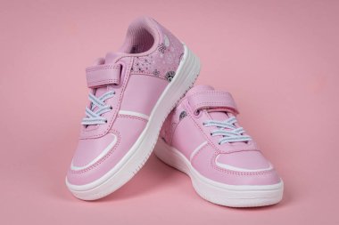 Pembe arka planda pembe çocuk ayakkabıları. Kızlar için çocuk ayakkabıları.