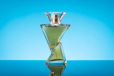 Mavi arka planda bir şişe parfüm. Güzel Şişe 'de Kadınlar Eau De Parfum. Modern Lüks Parfüm De Tuvalet