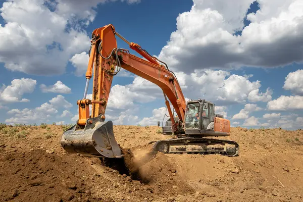 Kazıcı inşaat alanında Dünya 'yı kazıyor. Arazi Geliştirme, Altyapı ve Endüstriyel Toprak Taşıma Projesi 'nde Ağır Ekipman Çalışıyor