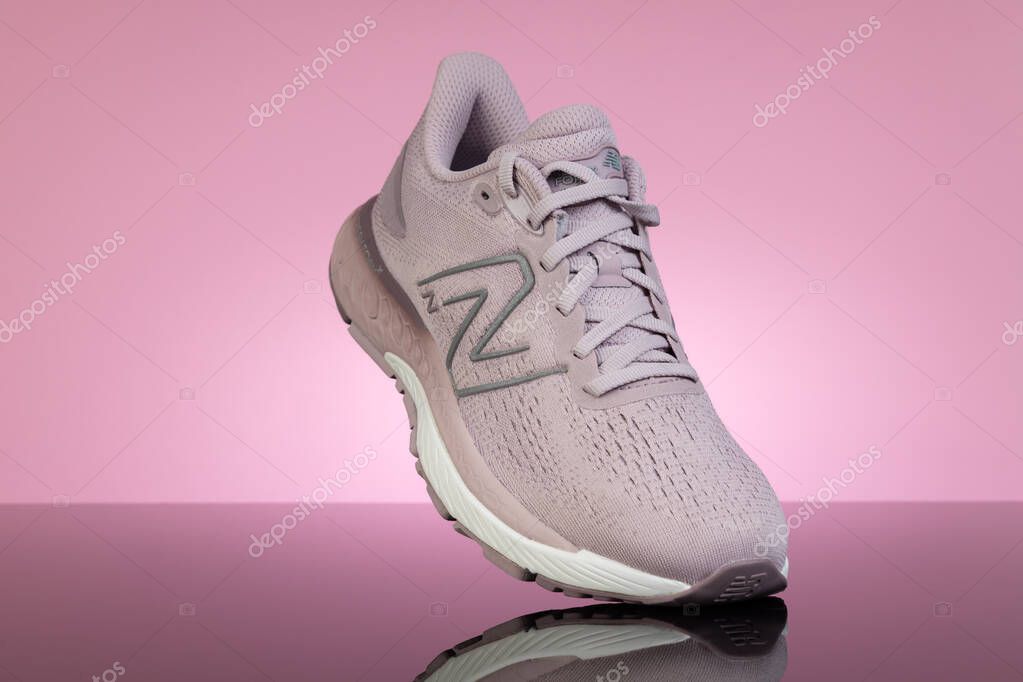 Varna, Bulgaria - April 18, 2025: New balance pink sport shoe on pink background. Fitness Lifestyle Concept, Product Display with Reflective Surface