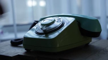 Telefon ahizesini kaldıran ve eski bir telefondan numara çeviren bir elin yakın görüntüsü. Retro plastik telefon.