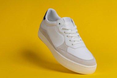 Sarı Arkaplanda Yüzen Şık Beyaz Ayakkabı. Modern Ayakkabı Tasarımı, Moda Konsepti, Minimalist Ürün Fotoğrafçılığı