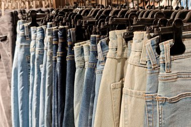 Giysi Mağazasında Askıda bulunan Denim Jeans 'in sıraları. Moda, Alışveriş ve Kostüm Seçimi.