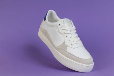 Mor Arkaplanda Yüzen Beyaz Sneaker. Modern Ayakkabı Tasarımı, Moda Konsepti, Minimalist Ürün Fotoğrafçılığı