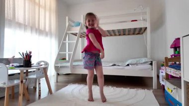 Tatlı küçük kız dans ediyor ve evde eğleniyor.