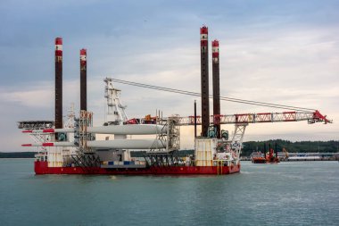Açık Deniz Rüzgâr Türbini Yükleme Gemisi. Devasa Turna ve Türbin Bıçakları Denizde. Yenilenebilir Enerji Lojistiği, Endüstriyel Denizcilik Mühendisliği ve Yeşil Enerji Geçiş Kavramı