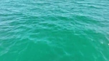 İnsansız hava aracı okyanus ve deniz üzerinde uçuyor. Suya yakın.