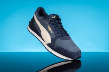 Varna, Bulgaristan - 16 Mayıs 2025. Mavi Yansıtıcı Yüzeyde Şık Mavi Puma Sneaker. Spor ve Yaşam Tarzı İçin Gündelik Ayakkabılar. Puma, büyük bir Alman çokuluslu şirketi. Ürün çekimi