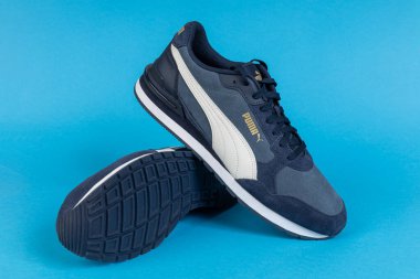 Varna, Bulgaristan - 16 Mayıs 2025. Mavi arka planda şık Mavi Puma Sneakers. Spor ve Yaşam Tarzı İçin Gündelik Ayakkabılar. Puma, büyük bir Alman çokuluslu şirketi. Ürün çekimi