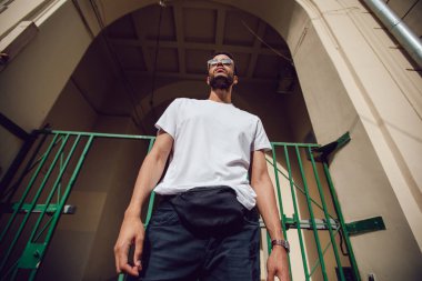 Beyaz, boş tişörtlü ve güneş gözlüklü Afro-Amerikan bir adam. Model.