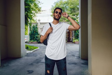 Beyaz, boş tişörtlü ve güneş gözlüklü Afro-Amerikan bir adam. Model.