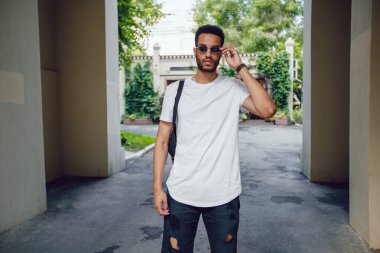 Beyaz, boş tişörtlü ve güneş gözlüklü Afro-Amerikan bir adam. Model.