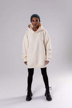 Attractive african american woman in oversized white hoodie. Mock-up.