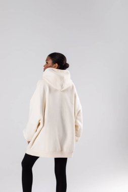 Attractive african american woman in oversized white hoodie. Mock-up.
