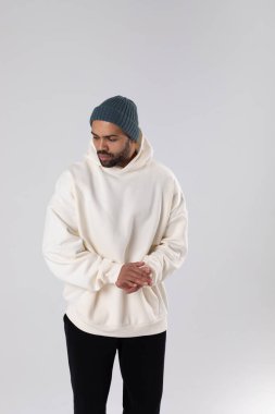 African American man in a knitted hat and white oversized hoodie. Mock-up.