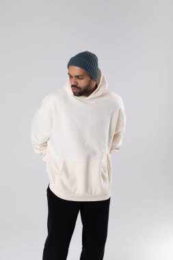 African American man in a knitted hat and white oversized hoodie. Mock-up.