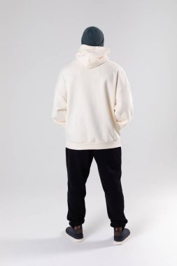 African American man in a knitted hat and white oversized hoodie. Mock-up. Back view.