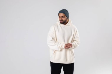 African American man in a knitted hat and white oversized hoodie. Mock-up.