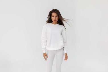 Beyaz eşofman altı ve beyaz arka planda poz veren güzel esmer kız. Yüksek kalite fotoğraf