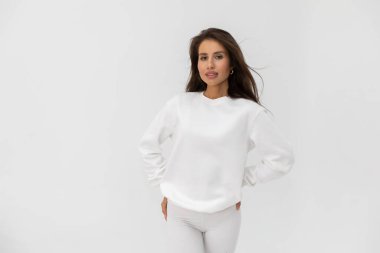 Beyaz eşofman altı ve beyaz arka planda poz veren güzel esmer kız. Yüksek kalite fotoğraf