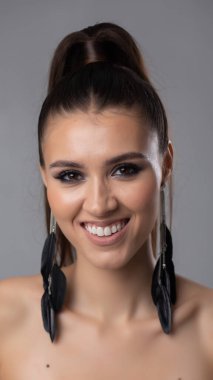 Şık saç stili ve çarpıcı küpeleri olan şık bir kadının nefes kesici ve büyüleyici portresi.