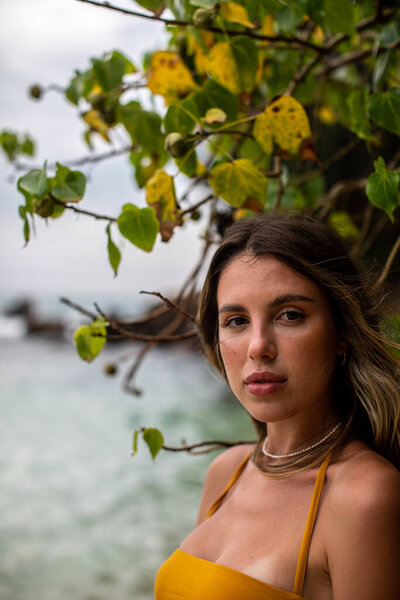 Захватывающий дух портрет молодой женщины в окружении пышной зелени возле прекрасного океана