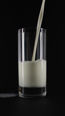 Temiz bir bardağa taze, kremalı sütün pürüzsüz ve nazikçe dökülmesi çarpıcı bir detay ve berraklık içinde yakalanır.