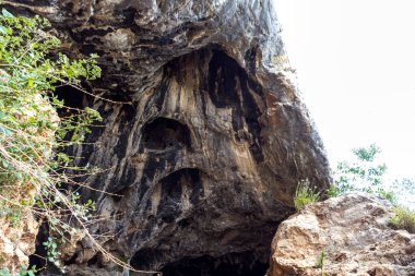 Taşlı bir mağaraya giriş, Ulusal Park 'ta yeşil ağaçlar, açık hava müzesi. Türkiye 'nin Antalya kenti yakınlarında yer alıyor