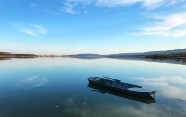 Sırbistan 'ın Romanya sınırı Tuna Nehri kıyısındaki panorama ve küçük bir balıkçı teknesi üzerinde