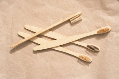 Kraft kağıt arka planında bir sürü doğal ahşap diş fırçası var. Doğal banyo ürünleri ve sıfır atık konsepti, organik diş fırçası. Model resmi