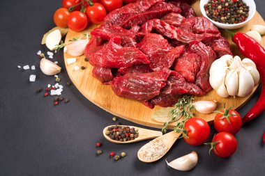 Baharatlı, baharatlı, acı biberli ve domatesli kesilmiş et ya da kuzu eti koyu beton arka planda. Pişirme güveci, azu veya diğer ana et yemekleri için organik dana eti