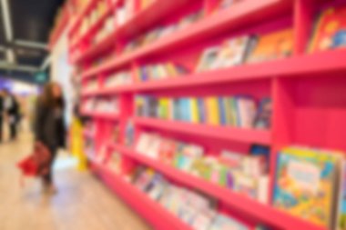 Bir sürü kitabı olan bulanık pembe raflar. Fotokopi alanı olan modern kitapçının içi bulanık