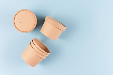 Kağıt yiyecek kapları - çorba ya da dondurma kapları açık mavi arkaplan üzerinde fotokopi alanı, taklit görüntü. Sürdürülebilir gıda paketleme konsepti. Yemek dağıtım servisi.