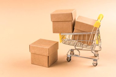 Açık kahverengi arka planda depolama veya taşımacılık için karton kutularla dolu alışveriş tepsisi. Sürdürülebilir ambalaj kavramı. Model resmi