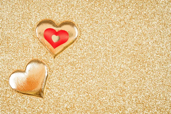 Composition with red and golden hearts over golden glitter background with copy space. Greeting card. Valentine\'s Day celebration concept