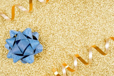 Şenlikli ışıltılı arka plan - mavi parlak mevcut yay ve altın parıltılı arka plan üzerinde altın metalik kurdele fotokopi alanı ile. Minimum modaya uygun arka plan. Lüks arkaplan