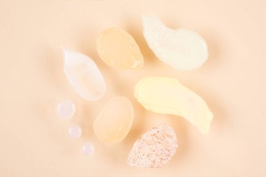 Set of cream, scrub and gel smudges - many cosmetic products smears over pastel background. Skincare and beauty products texture
