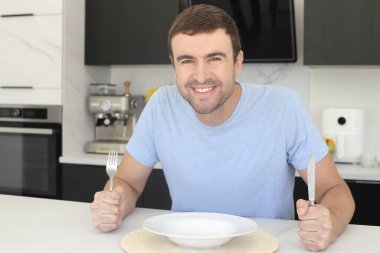 Mutfakta boş kâsesi olan yakışıklı bir gencin portresi.