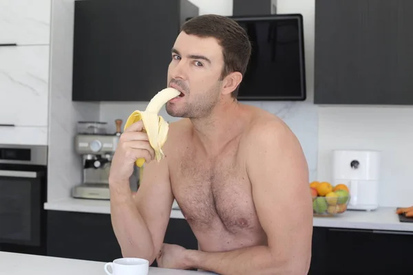Portret Przystojnego Młodzieńca Bez Koszuli Trzymającego Banana Kuchni — Zdjęcie stockowe