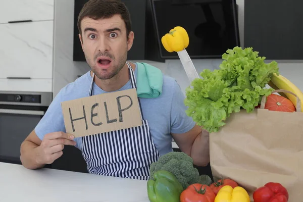 stock image portrait of handsome young man with help sign and bell pepper on knife at kitchen